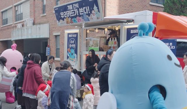 ©AP신문(AP뉴스)/ 이미지 제공 = 우리카드 ▲지난 12월 11일 노원구 파란나라 어린이집에서 진행된 '우리가 쏜다' 행사에서 원생 및 인근 주민들이 붕어빵을 받고 있다.