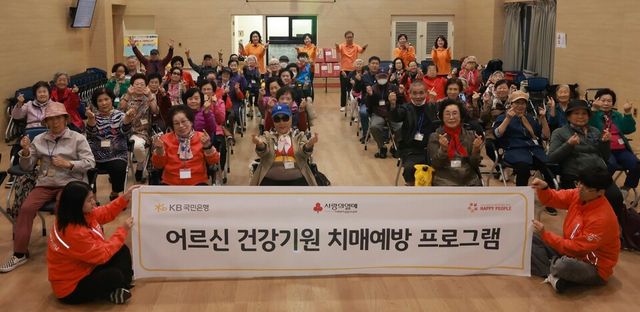 ©AP신문(AP뉴스)/이미지 제공 = KB국민은행 ▲지난 22일 서울 광진구 시립광진노인복지관에서 열린 ‘어르신 건강기원 치매예방 프로그램’에 참여한 어르신들이 기념촬영을 하고 있다.