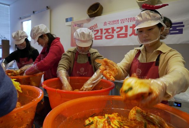 ©AP신문(AP뉴스)/이미지 제공 = 흥국생명 ▲18일 서울 종로구에 위치한 뮤지엄 김치간에서 흥국생명 임직원들이 김장김치 담그기 봉사활동을 진행하고 있다.