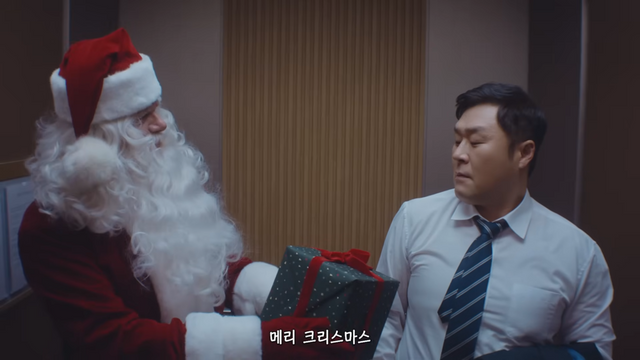 [AP신문 광고평론 No.1449]&nbsp; ​​​​​​​엘리베이터에서 선물을 건네는 산타. 사진 구글코리아 유튜브 캡처ⓒAP신문(AP뉴스)