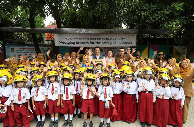 ©AP신문(AP뉴스)/ 이미지 제공 = KB손해보험 ▲KB손해보험은 지난 11일 인도네시아 자카르타 서부 지역에 위치한 발라라자(Balaraja) 초등학교에서 ‘이륜차 안전모 전달식’을 진행했다. 행사에 참여한 KB손해보험 관계자와 학생들이 기념촬영을 하고 있다.
