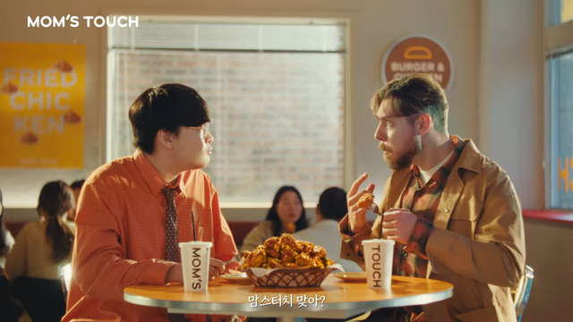 [AP신문 광고평론 No.1248] ​​​​​​​치킨을 먹으며 감탄하는 두 모델. 사진 맘스터치 유튜브 캡처ⓒAP신문(AP뉴스)