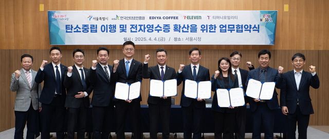 ©AP신문(AP뉴스)/ 이미지 제공 = 이디야커피 ▲&nbsp;4일 서울시청에서 열린 ‘전자영수증 도입’을 위한&nbsp;5자 업무협약(MOU)에서&nbsp;(왼쪽 다섯번째부터 차례로)이디야커피 조규동 대표이사,&nbsp;코리아세븐 김홍철 대표이사,&nbsp;서울시 권민 기후환경본부장,&nbsp;한국인터넷진흥원 김정희 본부장,&nbsp;티머니모빌리티 조동욱 대표이사 등 관계자들이 기념촬영을 하고 있다.