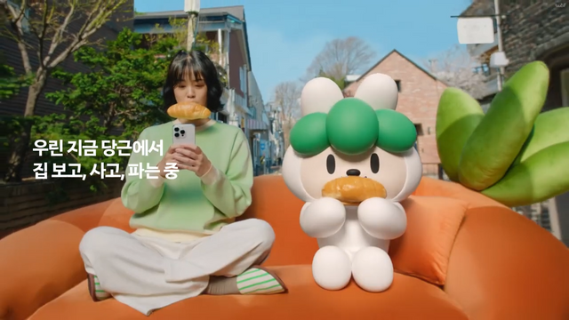 [AP신문 광고평론 No.1274]&nbsp; ​​​​​​​당근 소파 타고 동네를 구경하는 주인공과 당근 마스코트. 사진 당근 유튜브 캡처ⓒAP신문(AP뉴스)