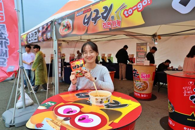 ©AP신문(AP뉴스)/이미지 제공 = 농심 ▲농심 완도장보고수산물축제 참가자가 농심 너구리를 즐기고 있다