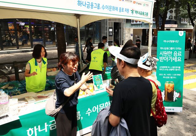 ©AP신문(AP뉴스)/이미지 제공 = 하나금융지주 ▲하나금융그룹은 지난 14일 ‘제20회 서울특별시 수어문화제’에 참여해 자원봉사활동을 실시했다. 이날 자원봉사활동에 참여한 그룹 임직원들이 하나금융그룹 부스를 찾은 농인과 가족들에게 음료를 나눠주며 수어로 인사를 하고 있다.