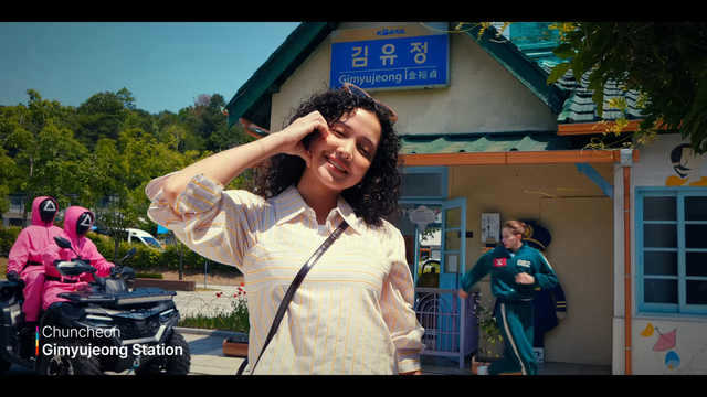 [AP신문 광고평론 No.1308]&nbsp;​​​​​​​사진 찍고 있는 관광객 뒤로 핑크 병정이 주인공을 쫓고 있다. 사진 한국관광공사 유튜브 캡처ⓒAP신문(AP뉴스)