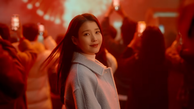 [AP신문 광고평론 No.1462]&nbsp; ​​​​​​​새해 맞이 불꽃놀이를 배경으로 서있는 아이유. 사진 우리금융그룹 유튜브 캡처ⓒAP신문(AP뉴스)