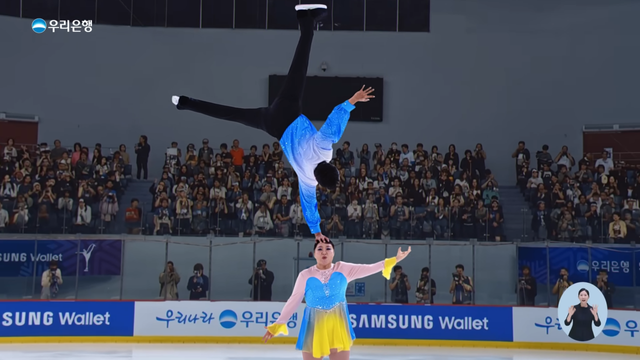 [AP신문 광고평론 No.1510]&nbsp; ​​​​​​​빙판 위에서 이수지가 김원훈을 머리로 들어올리는 기술을 선보이고 있다. 사진 우리은행 유튜브 캡처ⓒAP신문(AP뉴스)