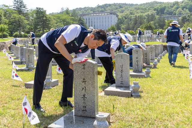 ©AP신문(AP뉴스)/이미지 제공 = HD현대 ▲HD현대 정기선 회장이 5월 29일 국립서울현충원을 찾아 임직원들과 함께 참전용사의 비석을 닦고 있다.
