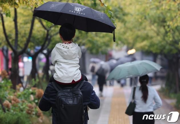 가을비가 내리는 19일 오전 서울 종로구 광화문네거리 인근에서 우산을 쓴 부자가 길을 지나가고 있다. 2023.10.19/뉴스1 ⓒ News1 김도우 기자