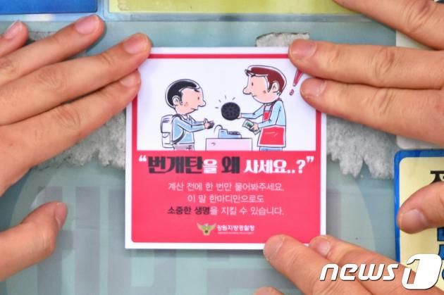 1일 오전 강원도내 한 마트에서 경찰관들이 업주에게 '번개탄을 왜 사세요' 문구가 들어있는 스티커를 전달하고 있다. (강원지방경찰청 제공) 2018.6.1/뉴스1 ⓒ News1 김경석 기자