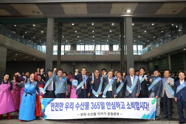 우리 수산물 지키기 운동본부가 14일 부산시수협 자갈치위판장에서 ‘수산물 지키기 릴레이 캠페인’을 개최한 가운데 노동진 수협중앙회장(오른쪽 아홉번째)을 비롯한 참석자들이 우리 수산물은 안전하다고 외치며 파이팅을 하고 있다.