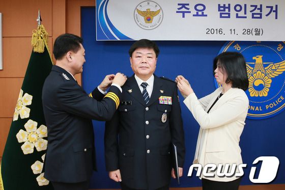 2016년 11월 28일 이철성 경찰청장이 서울 서대문구 경찰청에서 열린 '주요 범인검거 특별승진 임용식'에서 18년 전인 1998년 서울 노원에서 발생한 가정주부 살해사건 범인을 검거한 유공경찰관 김응희 경감(경위에서 1계급 특진)에게 계급장을 달아주고 있다. (경찰청 제공) 2016.11.28/뉴스1