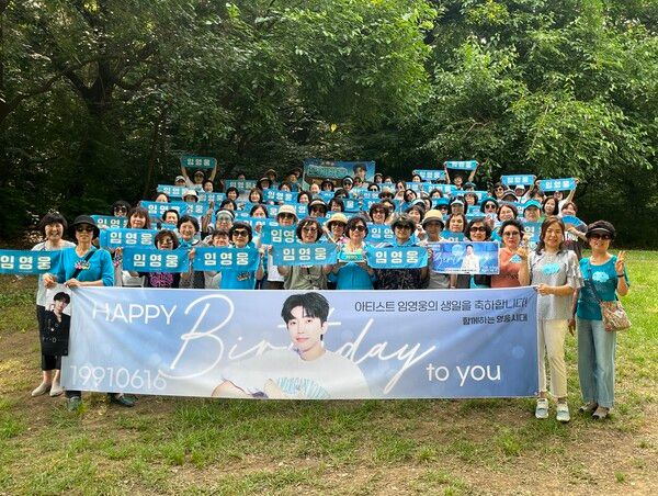 포에버웅 스터디 회원들이 임영웅 생일을 기념하여 사진 촬영하고 있다.