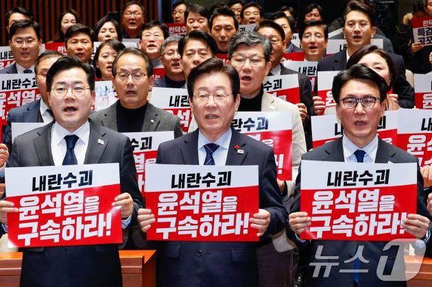 이재명 더불어민주당 대표와 박찬대 원내대표를 비롯한 의원들이 23일 오후 서울 여의도 국회에서 열린 의원총회에서 '내란수괴 윤석열을 구속하라'라고 적힌 피켓을 든 채 구호를 외치고 있다. 2024.12.23/뉴스1 ⓒ News1 안은나 기자