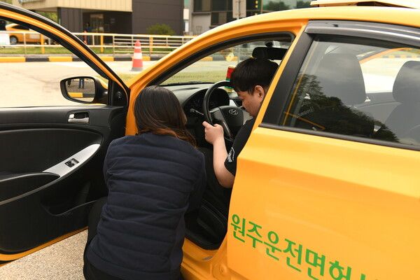 공단 작업치료사가 참가자에게 운전방법을 설명하는 모습(사진제공 = 도로교통공단)