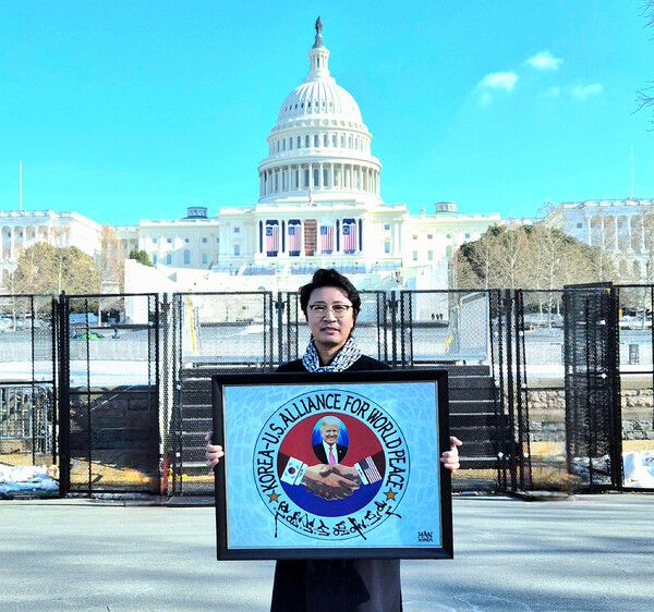 한한국 세계평화작가가 미국 워싱턴 DC 의회의사당앞에서 ‘한미동맹 세계평화’ 작품을 들고 퍼포먼스를 하고 있다.(사진=한한국 세계평화작가)