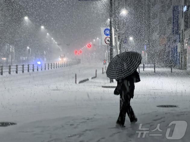서울 송파구 거리에서 시민이 쏟아지는 눈발을 헤치며 발걸음을 재촉하고 있다. ⓒ News1 박정호 기자