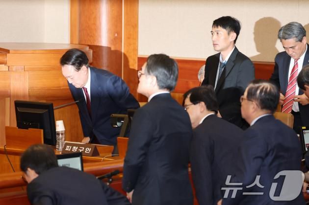 윤석열 대통령이 23일 오후 서울 종로구 헌법재판소 대심판정에서 열린 탄핵심판 4차 변론기일에 출석해 헌법재판관들이 입장한 뒤 다시 자리에 앉고 있다. 2025.1.23/뉴스1 ⓒ News1 사진공동취재단