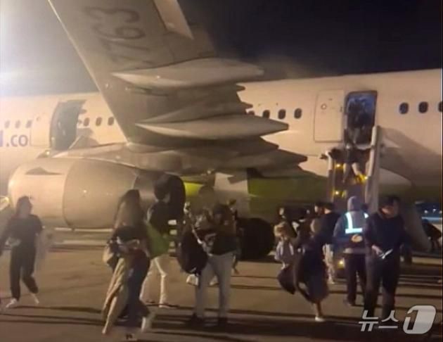 28일 오후 부산 강서구 대저동 김해공항에서 홍콩행 에어부산 항공기에서 화재가 발생해 탑승 승객들이 비상탈출을 하고 있다. 승객 169명, 승무원 7명 모두 대피했으며 화재는 진압됐다. (독자 제공)2025.1.29/뉴스1