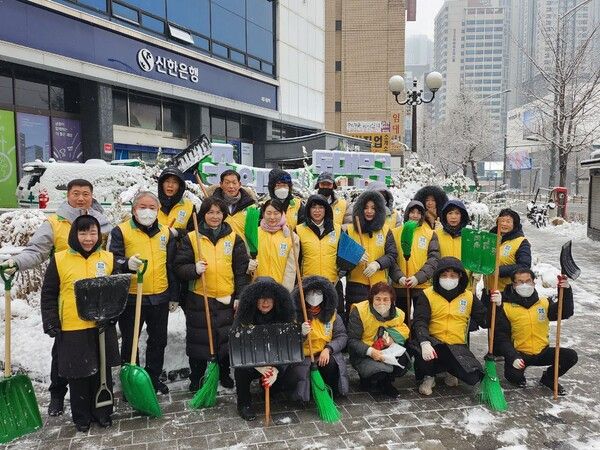 5일 동대문구 경동시장 일대에서 신천지자원봉사단 동대문지부가 제설 작업 후 기념 촬영하고 있다.(사진 제공 = 신천지자원봉사단 동대문지부)