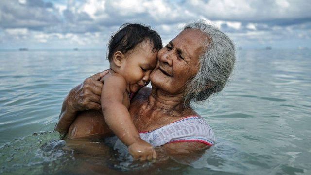 아기와 바다에서 놀고 있는 할머니의 모습
