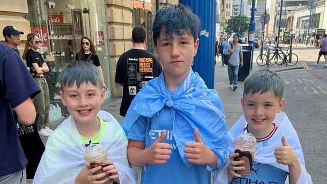 엄지를 들고 웃고 있는 어린이 팬 3명의 모습