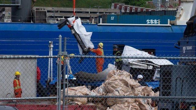 잠수정의 다리로 보이는 부분이 줄에 묶여 옮겨지는 모습