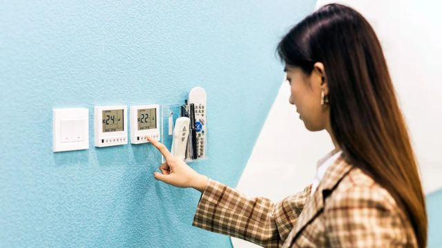 에어컨 온도를 조정하는 여성의 모습