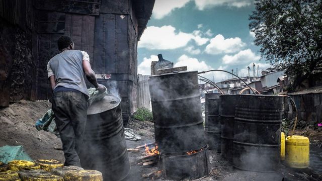 발효된 창아 혼합물이 담긴 가열된 강철 통을 밀고 있는 남성