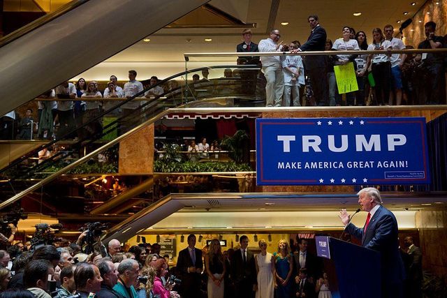 뉴욕 트럼프 타워에서 ‘미국을 다시 위대하게’라는 문구가 적힌 파란색 현수막 아래서 연설 중인 트럼프의 모습