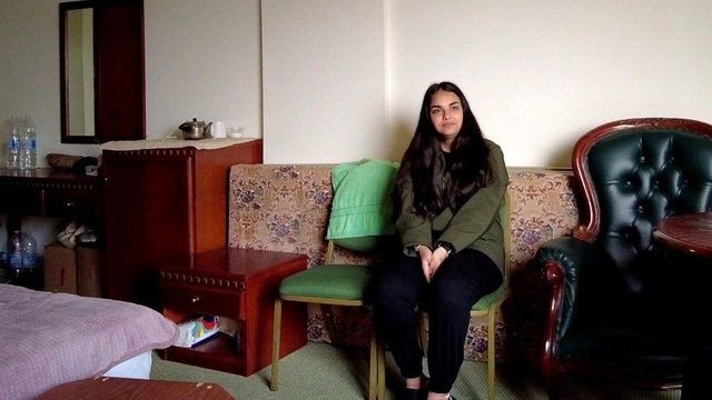 호텔 방 안 의자에 앉아 있는 파티마 