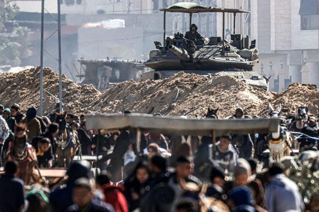 올해 1월 30일, 이스라엘군 탱크를 배경으로 칸 유니스에서 탈출하는 팔레스타인 난민들의 모습