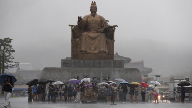 17일 폭우가 내리는 가운데 서울 광화문광장에 우산을 들고 서있는 시민들
