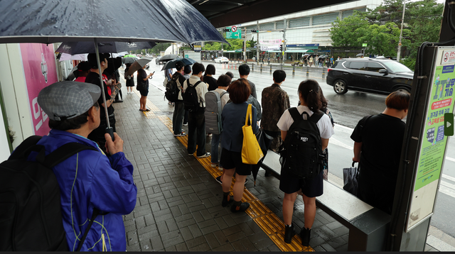 수도권과 중부지방을 중심으로 폭우로 덕정역-연천역 구간 운행이 중단된 18일 오전 경기 양주 지하철 1호선 덕정역 앞 동두천 방향 버스 정류장에서 시민들이 버스를 기다리고 있다