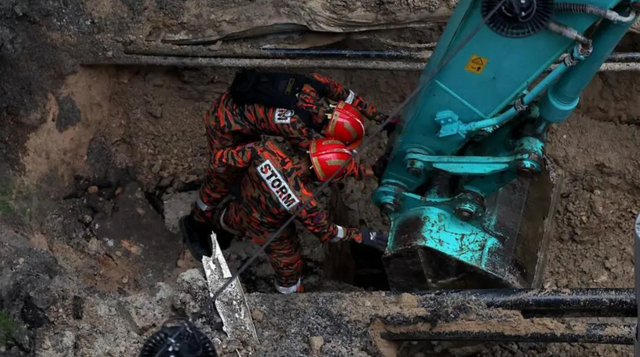 말레이시아 소방 당국이 쿠알라룸푸르의 싱크홀 사고 현장을 조사하고 있다