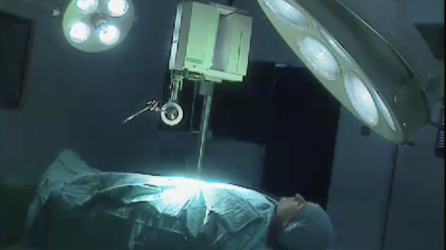 병원 침대에서 환자를 수술하는 로봇