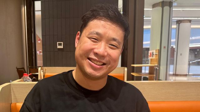 25세의 쑨잔이 레스토랑에서 미소를 짓고 있다 