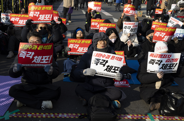 윤석열 대통령 관저 주변에 모인 집회자들이 윤석열 대통령 체포를 요구하는 펫말을 들고 있다