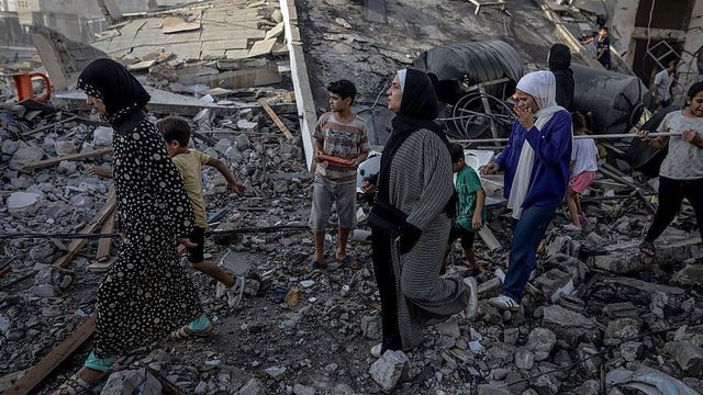 2025년 10월 3일, 가자지구 가자 시 오마르 알-무크타르 거리에서 이스라엘의 공격 이후, 여성과 아이들이 잔해 위를 걸으며 그 지역을 떠나고 있다