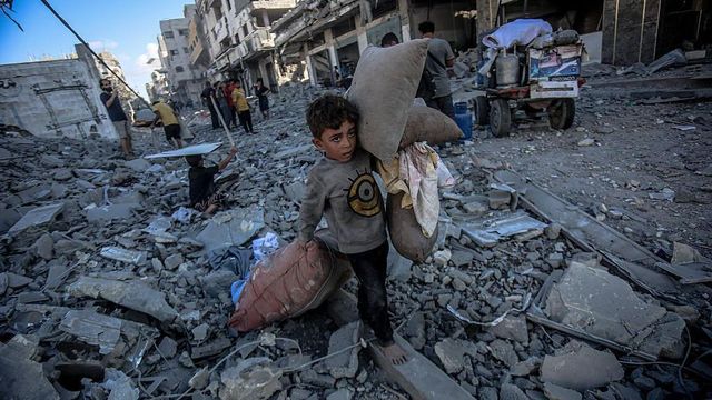 팔레스타인 어린이들이 2025년 9월 30일 가자시티의 아부 하시라 거리에서 이스라엘의 공습으로 무너진 잔해 속에서 쓸만한 물건들을 모으고 있다. 배경에는 여러 건물이 완전히 파괴된 모습이 보인다