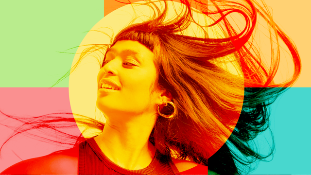 진한 머리색을 가진 여자가 웃고 있다. 