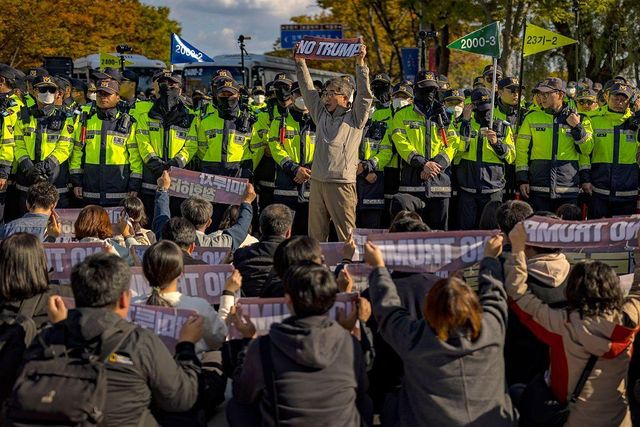 "노 트럼프" 슬로건을 들고 시위하는 사람들. 뒤로는 경찰들이 서있다.