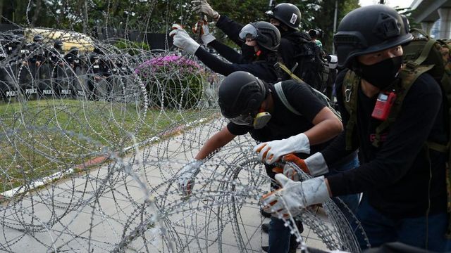 2020년 11월 29일 태국 방콕에서 열린 시위 중, 반정부 시위대가 왕실 근위대 본부인 제11보병연대 근처 철조망을 제거하는 모습