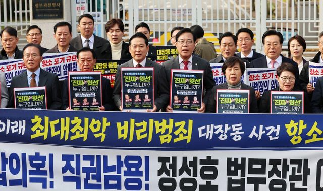 국민의힘 장동혁 대표와 송언석 원내대표를 비롯한 의원들이 11일 오후 경기 과천시 법무부 청사 앞에서 열린 '대장동 사건 1심 항소 포기' 긴급 현장 규탄대회에서 피켓을 든 채 구호를 외치고 있다