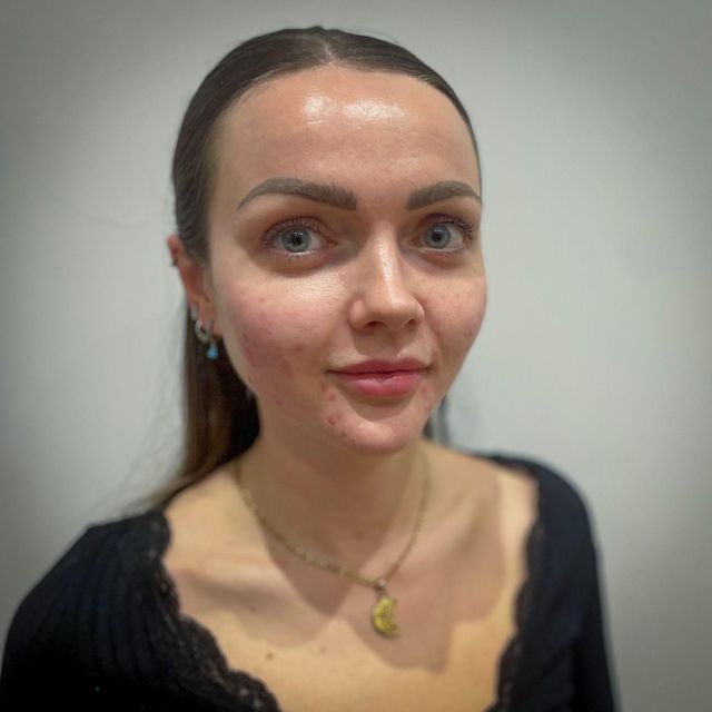 애비는 긴 갈색 머리를 하고 있으며 카메라를 정면으로 바라보고 있다.