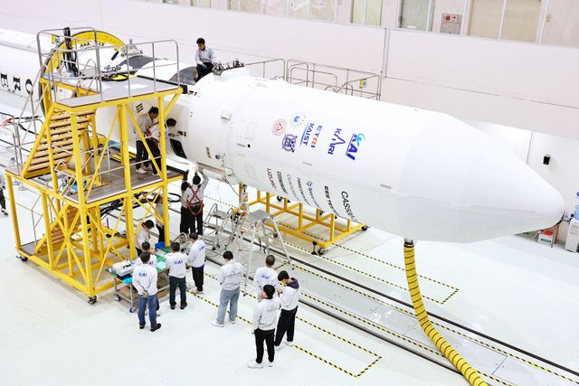 나로우주센터 조립동에서 연구진들이 누리호 4차 발사 총조립을 수행하고 있다. 가로로 누운 로켓 주위로 연구진들이 모여서 논의를 하고 있다