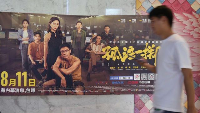 '고주일척' 영화 포스터 앞을 한 시민이 지나고 있다