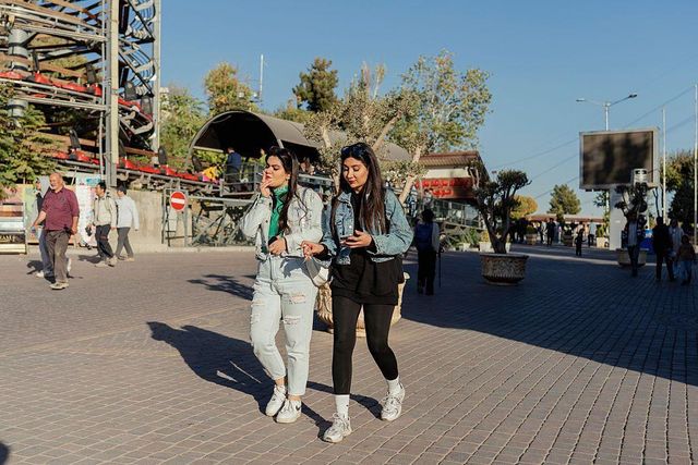 히잡을 쓰지 않고 데님 자켓에 바지 차림으로 담배를 피우며 걷는 여성들의 모습